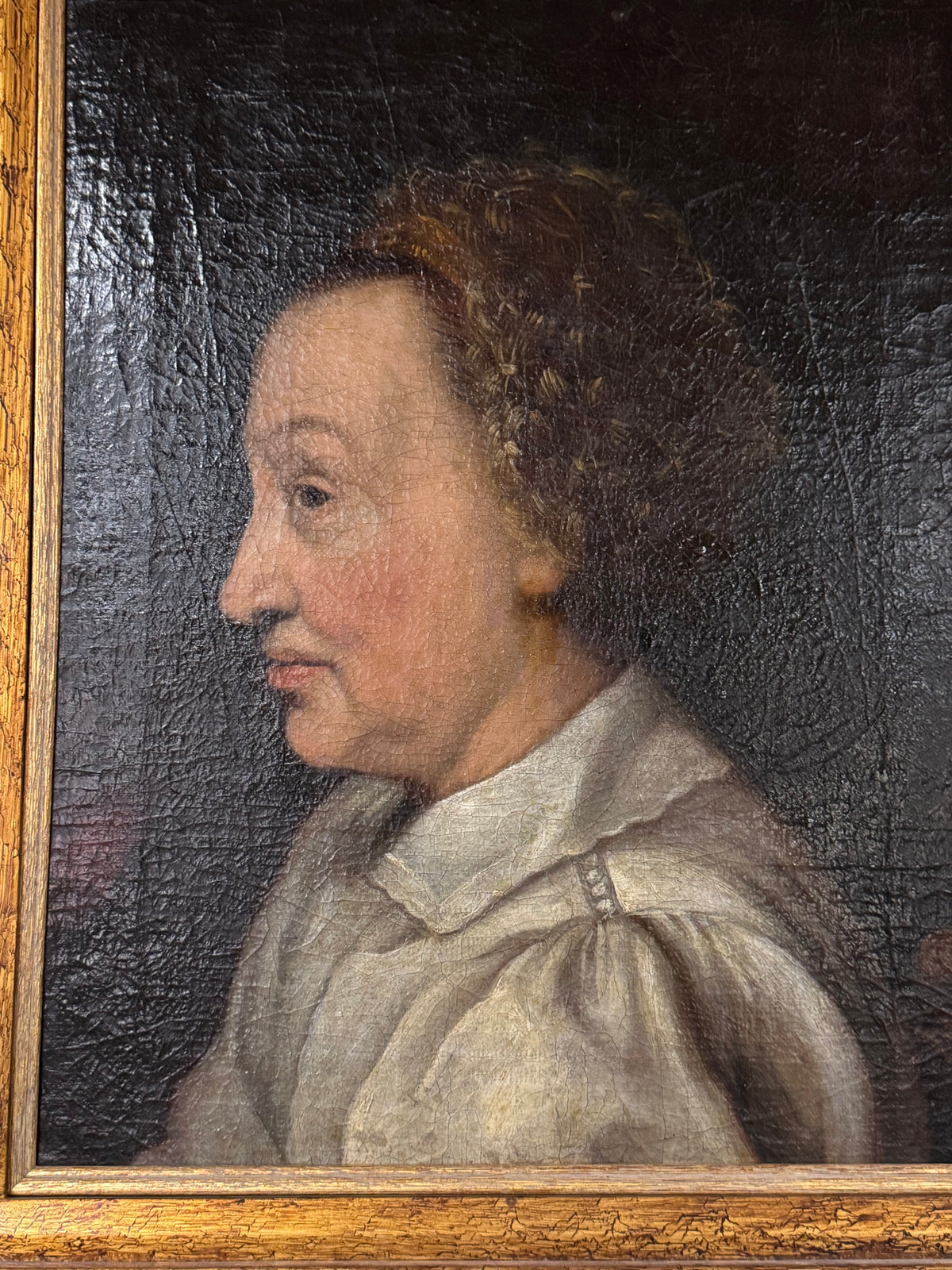 Close-up of the painted face and white shirt showing age craquelure