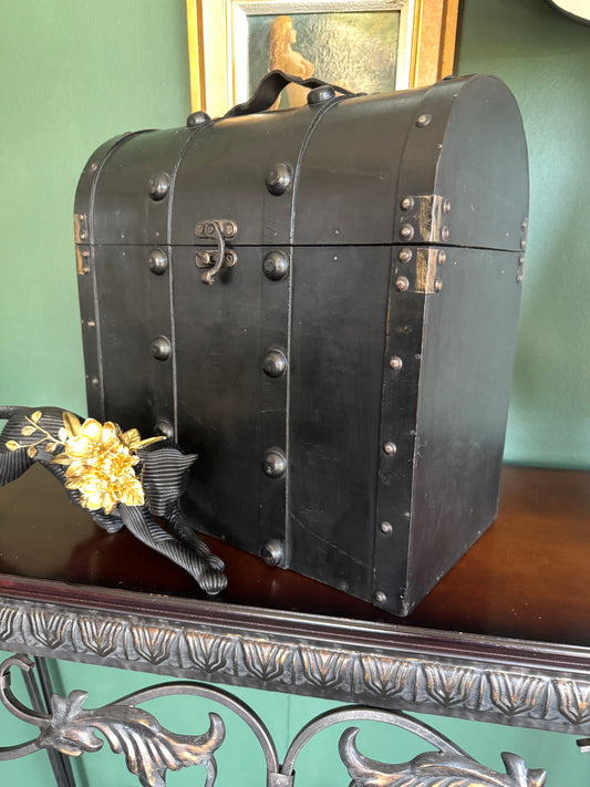 Vintage black wooden dome-top treasure chest with studded bands and brass-tone latch